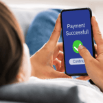 Person holding a phone with a 'Payment Successful' screen.