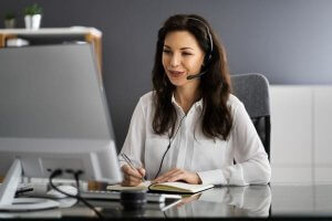 Customer service agent working with a headset at a desk.