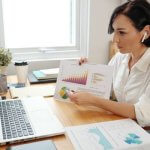 Woman presenting financial charts during an online video call.