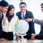 Group of business professionals looking at a globe together.