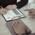 Close-up of a person filling out a resume during an interview.