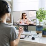 A woman attending an online meeting with a mentor