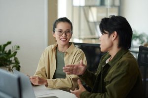 Two colleagues engaged in a discussion in a modern office setting