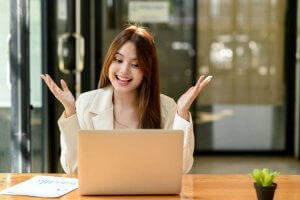 Smiling woman working on laptop at desk