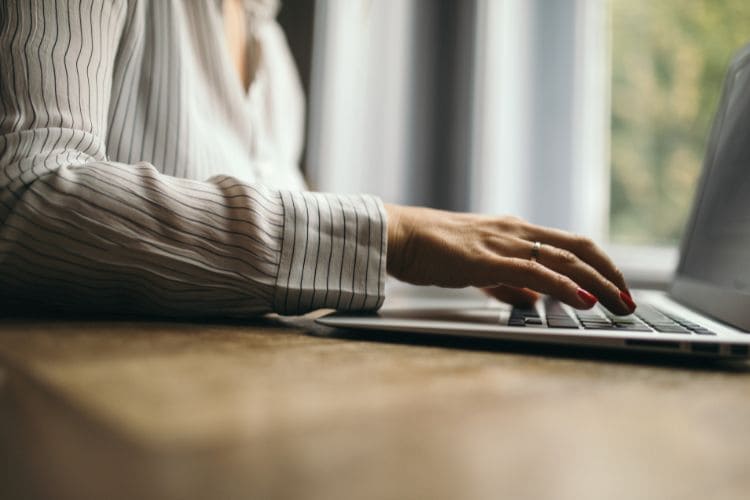 Close-up of woman’s hand typing on laptop