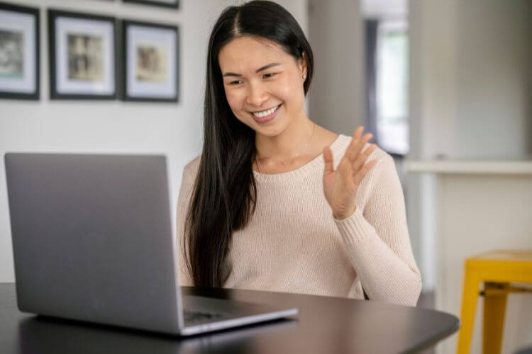 A woman happily engaged with her laptop, showcasing her work as a virtual assistant.