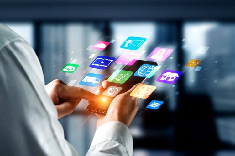 A businessman interacts with a smartphone, showcasing multiple app icons on the screen