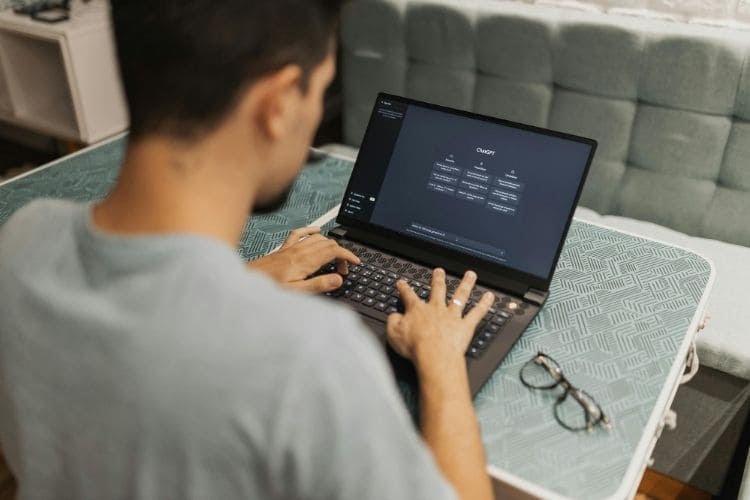 User working on a laptop displaying the ChatGPT interface to optimize remote productivity.