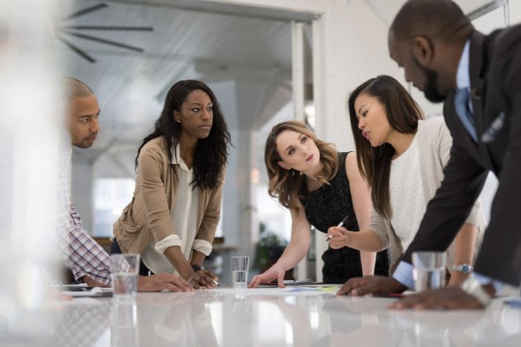 CreaThink Solutions | PEO vs. EOR in the Philippines: A UK Employer’s Guide to Compliance and Hiring Diverse business team collaborating in a modern office meeting