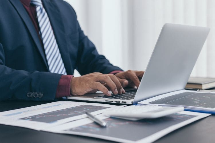 Business professional analyzing data on laptop at desk