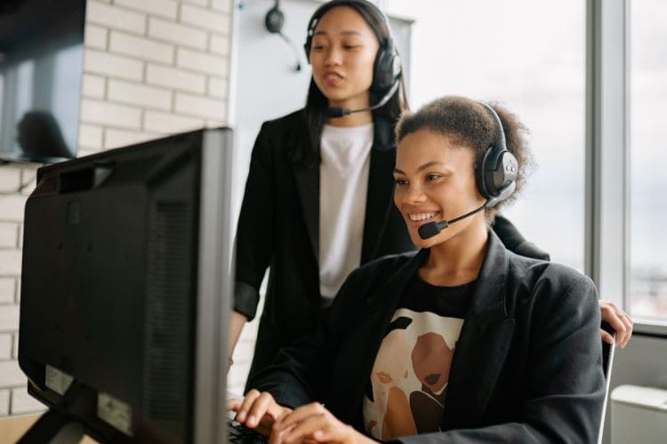 Customer support team using headsets at computer