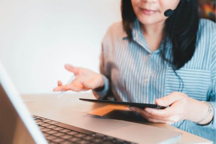 Female virtual assistant using tablet and headset during remote work session