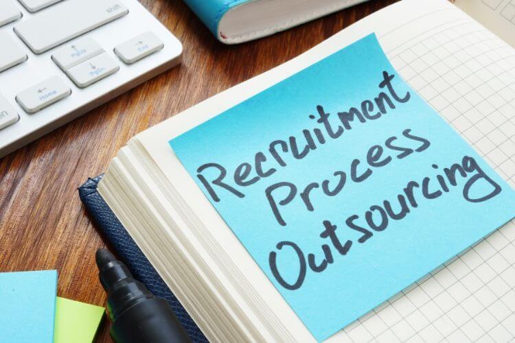 Recruitment Process Outsourcing (RPO) concept written on a notepad representing outsourced hiring solutions.