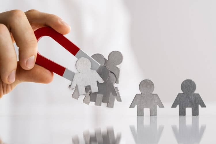 Magnet attracting employee icons to represent recruitment, talent acquisition, and outsourcing services.