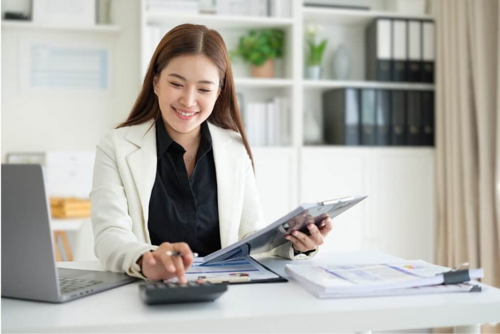 CreaThink Solutions | How a Filipino Virtual Assistant Can Improve Efficiency in Your Accounting Practice Accountant calculating financial reports and reviewing business documents in a modern office.