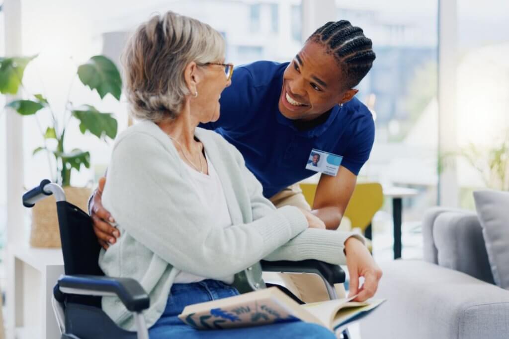 CreaThink Solutions | NDIS Workforce Challenges: How Australian Providers Can Overcome Staff Shortages Caregiver assisting an elderly woman in a wheelchair with compassionate home care support.