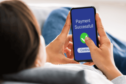 Person holding a phone with a 'Payment Successful' screen.