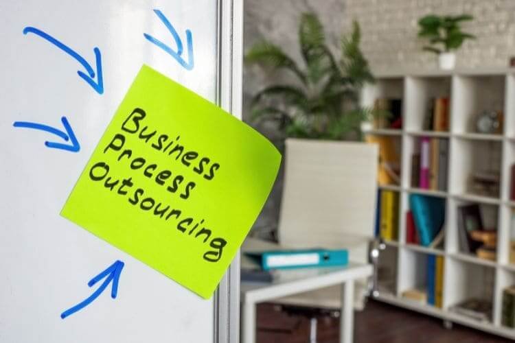 Sticky note reading "Business Process Outsourcing" on a whiteboard.