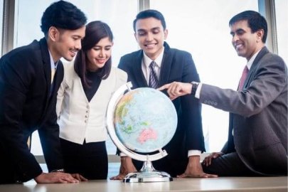 Group of business professionals looking at a globe together.