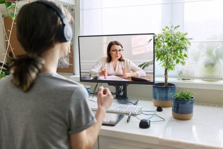 A woman attending an online meeting with a mentor