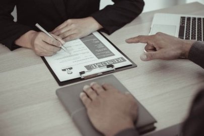 Close-up of a person filling out a resume during an interview.