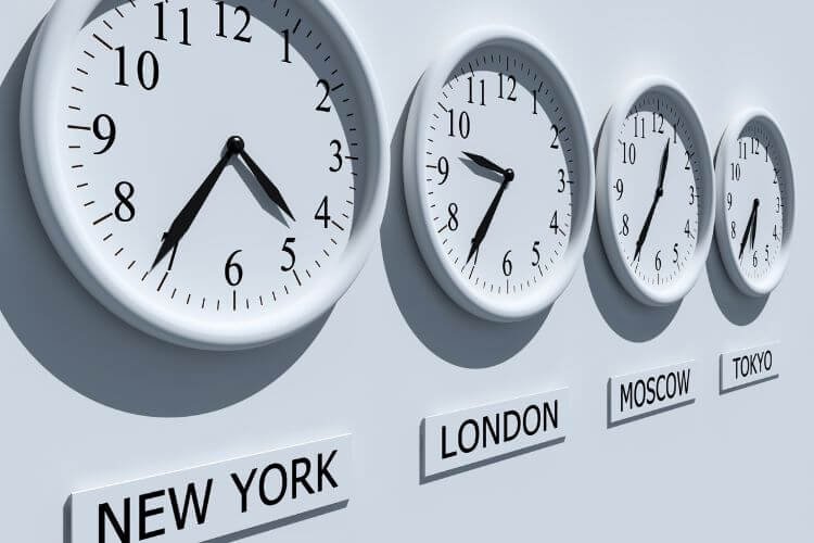 Four wall clocks display different times, labeled in various languages, illustrating time zone management.